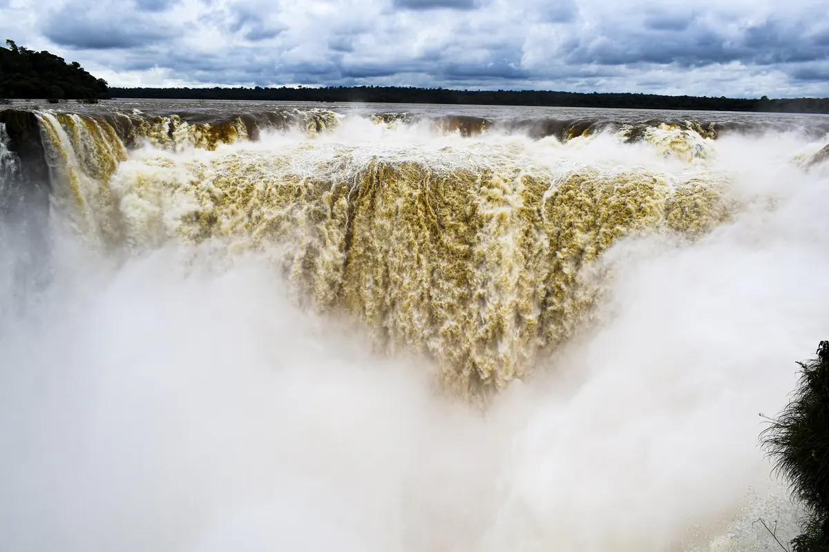 The Devil's Throat at Iguazú Falls, a wide curtain of brown water falling into white mist